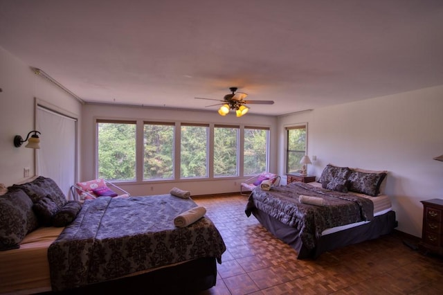 tiled bedroom with ceiling fan and multiple windows