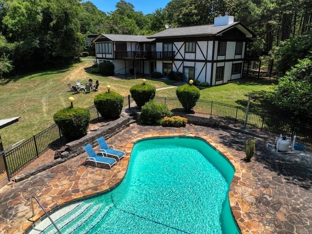 view of pool with a patio area and a yard