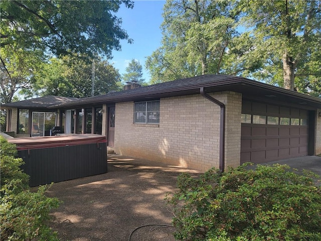 view of home's exterior featuring a garage and a hot tub