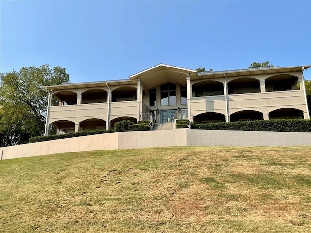 view of front of home with a front yard and a balcony