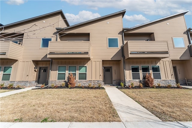 multi unit property with a front yard and a balcony