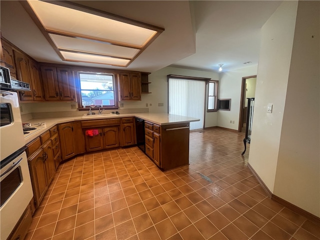 kitchen featuring tile flooring, sink, black dishwasher, and kitchen peninsula