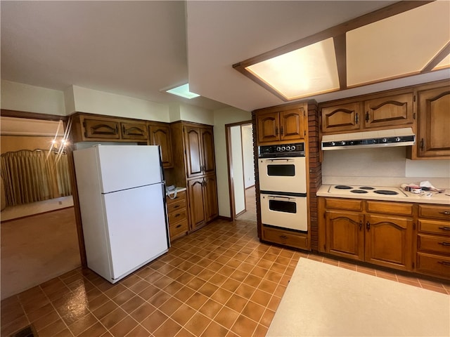 kitchen featuring exhaust hood, white appliances, and tile floors