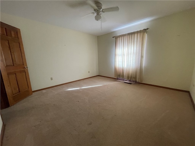 spare room featuring ceiling fan and light carpet