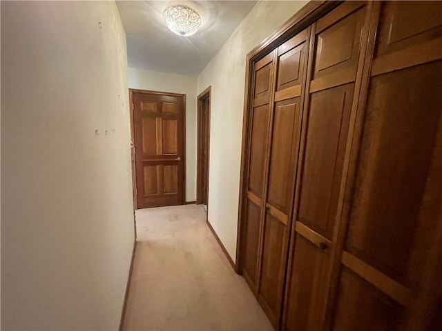 hallway featuring light colored carpet