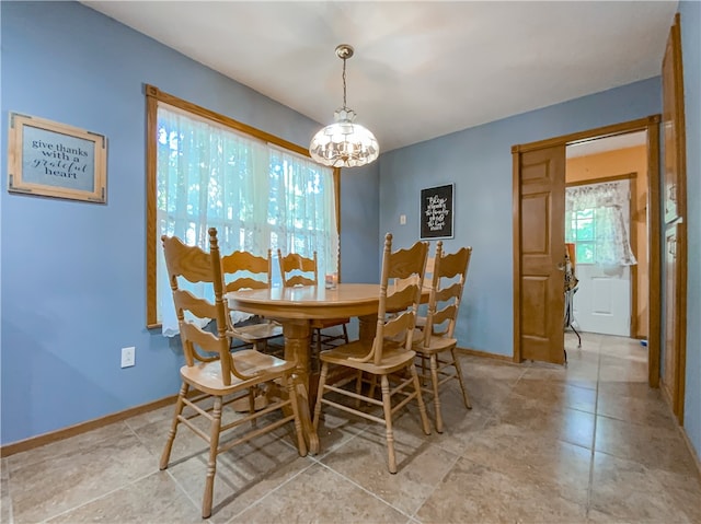 tiled dining space with a chandelier