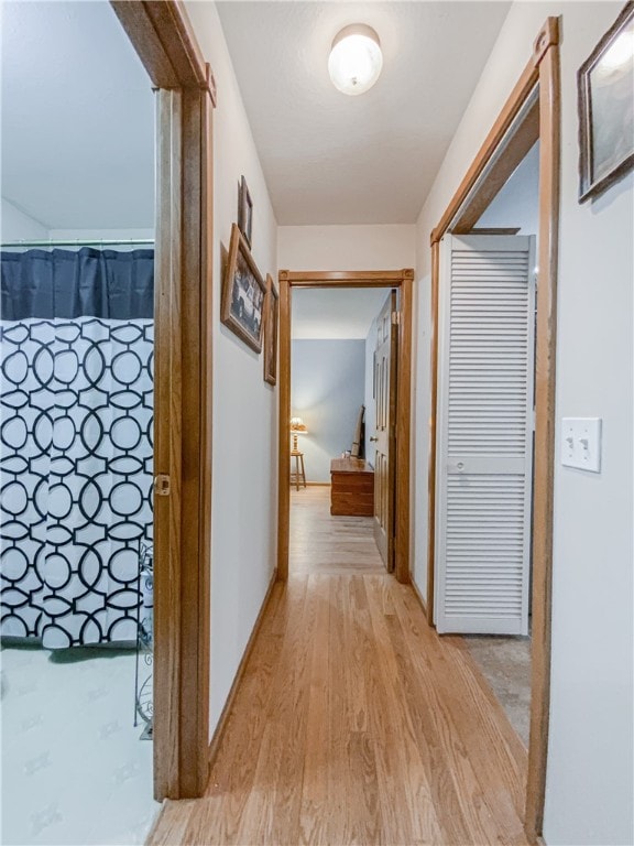 corridor with light hardwood / wood-style floors