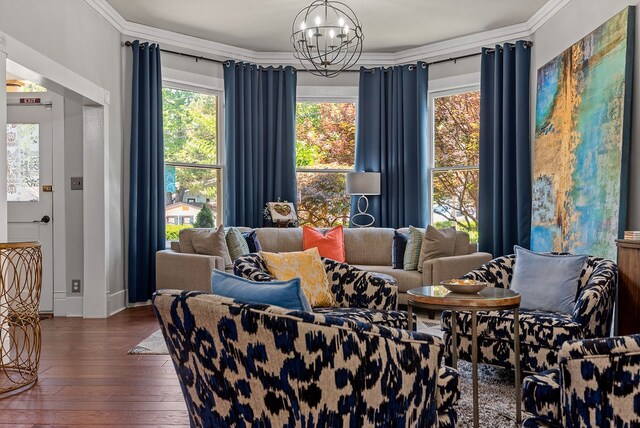 sitting room featuring ornamental molding, dark wood-type flooring, and an inviting chandelier