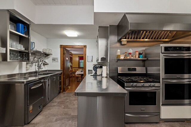 kitchen featuring stainless steel counters, light tile flooring, appliances with stainless steel finishes, sink, and wall chimney exhaust hood