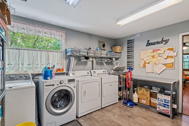 clothes washing area with light wood-type flooring and separate washer and dryer