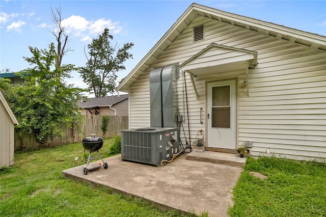 exterior space with central air condition unit, a yard, and a patio area