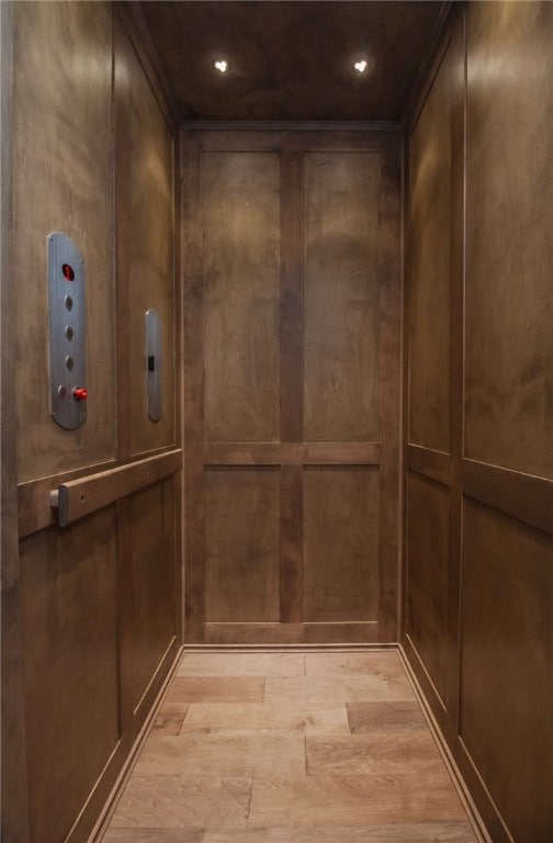 room details featuring elevator and light hardwood / wood-style floors