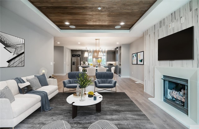 living room featuring a chandelier, wooden ceiling, a raised ceiling, and dark wood-type flooring