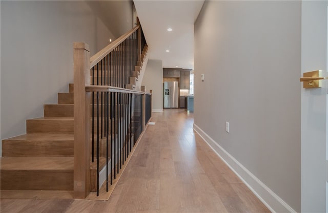 stairway with light hardwood / wood-style floors