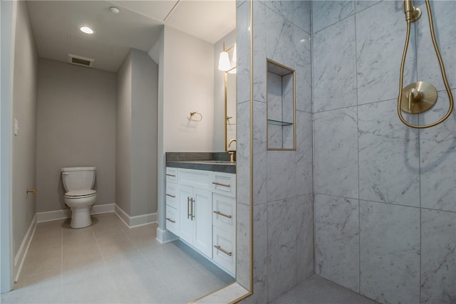 bathroom with tile flooring, toilet, and vanity