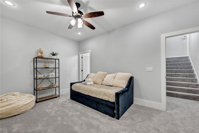 living area featuring ceiling fan and light colored carpet