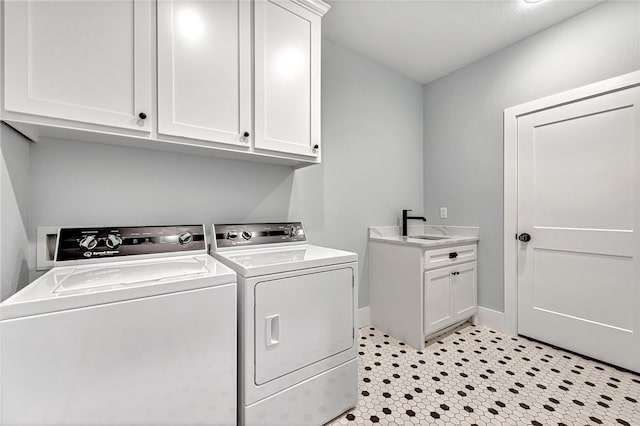 washroom featuring cabinets, light tile floors, and washer and dryer