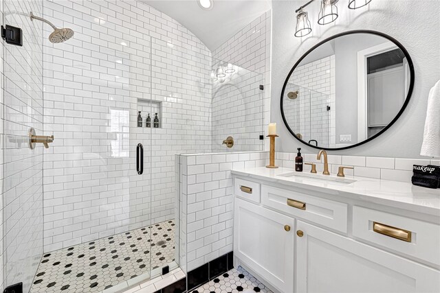 bathroom with oversized vanity, walk in shower, backsplash, tile walls, and tile floors