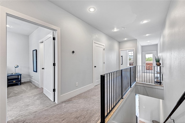 hall featuring light colored carpet