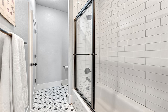 bathroom with tile floors and combined bath / shower with glass door