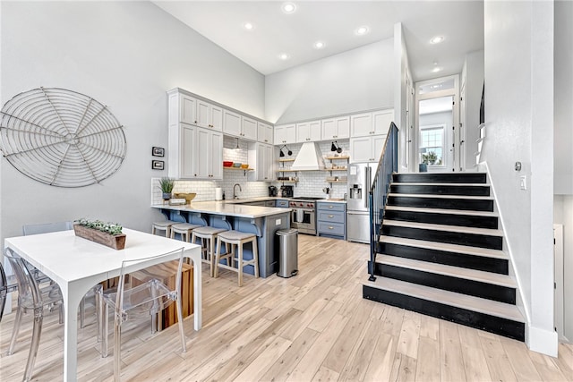 kitchen with white cabinets, tasteful backsplash, premium appliances, and a breakfast bar