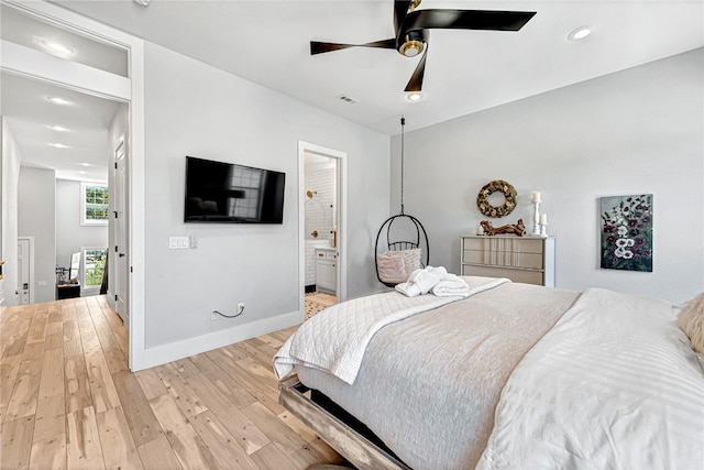 bedroom with ceiling fan, light hardwood / wood-style flooring, and ensuite bath