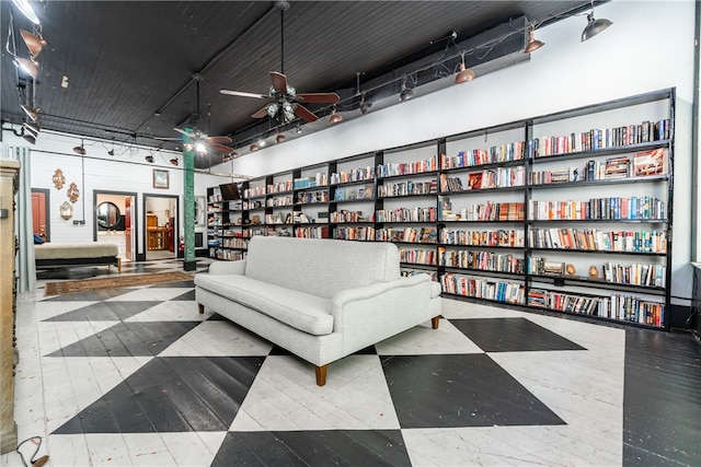 living area featuring ceiling fan and a towering ceiling