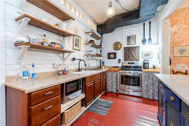 kitchen featuring dark hardwood / wood-style floors, pendant lighting, sink, appliances with stainless steel finishes, and light stone countertops