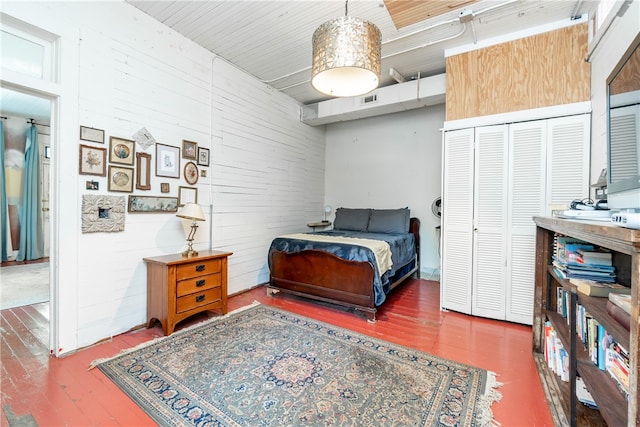 bedroom with a closet, wooden ceiling, and dark hardwood / wood-style flooring