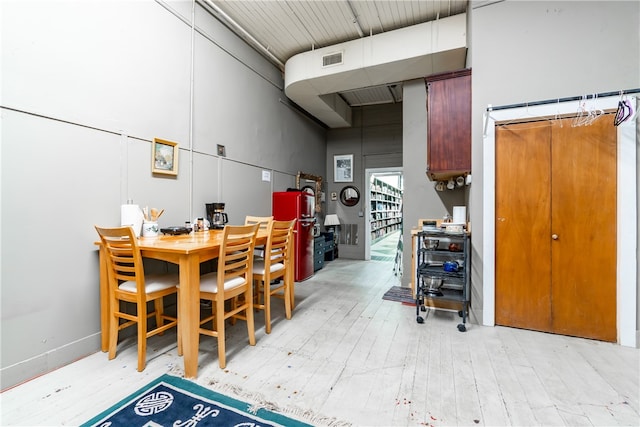 interior space with light hardwood / wood-style floors and a high ceiling