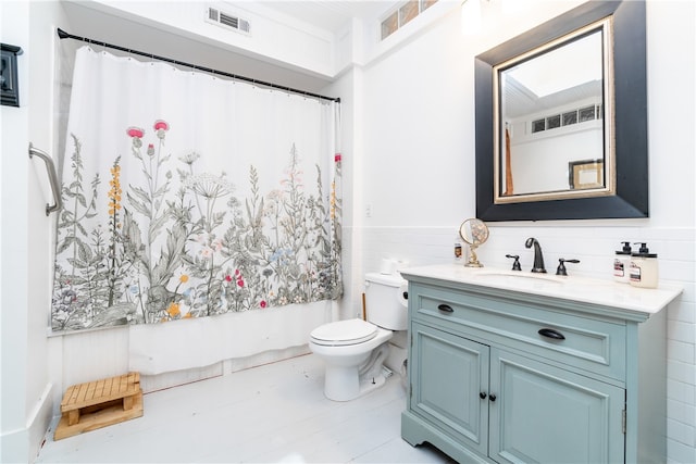 full bathroom featuring tile walls, tile floors, toilet, and vanity