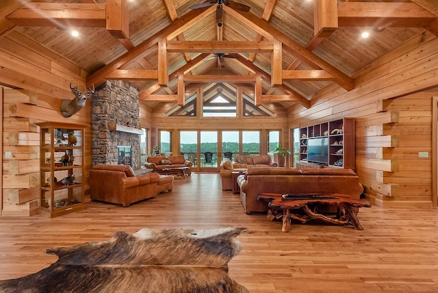 living room featuring wooden walls, a stone fireplace, wood ceiling, and light hardwood / wood-style flooring