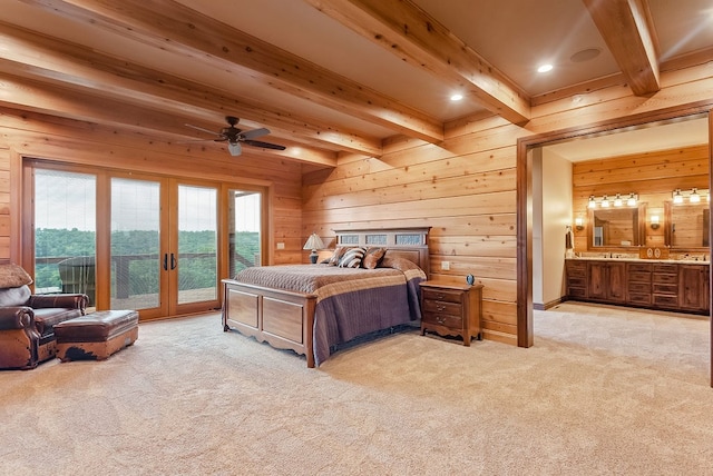 carpeted bedroom with ensuite bathroom, beamed ceiling, ceiling fan, access to outside, and french doors