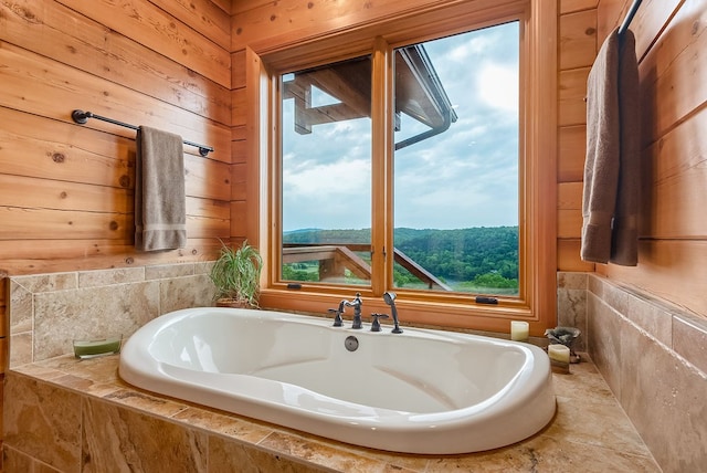 bathroom featuring a relaxing tiled bath, a mountain view, and a wealth of natural light