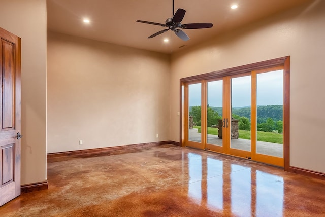 unfurnished room featuring ceiling fan and a towering ceiling