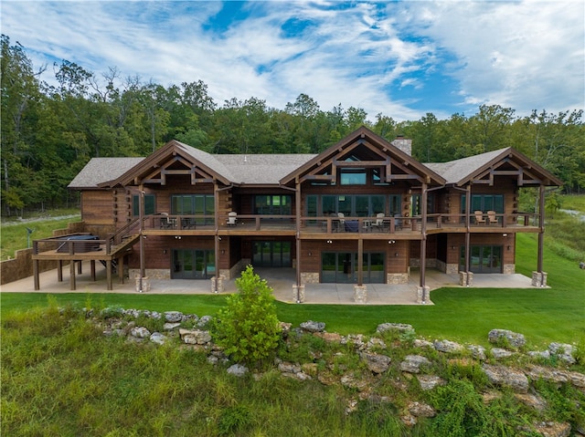 back of house with a lawn, a balcony, and a patio