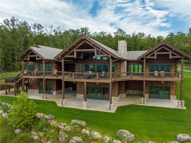 back of property with a lawn, a patio, and a wooden deck