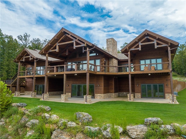 rear view of house featuring a yard, a patio area, and a balcony