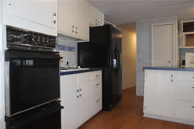 kitchen with white cabinetry, dark hardwood / wood-style flooring, and black appliances