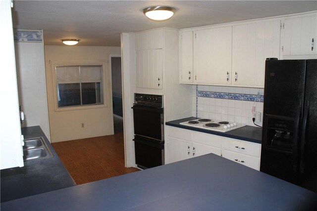 kitchen with sink, black appliances, white cabinets, dark hardwood / wood-style flooring, and decorative backsplash