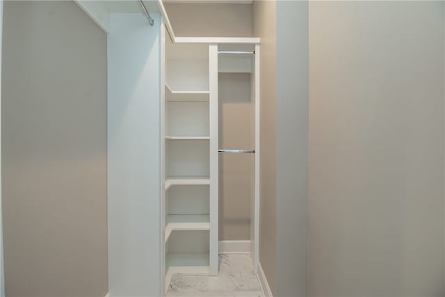 walk in closet featuring light tile floors