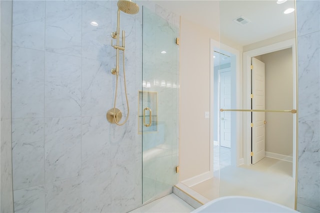 bathroom with a shower with shower door and tile flooring