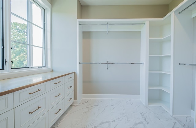 walk in closet with light tile flooring