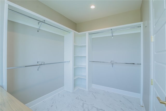 walk in closet with light tile floors