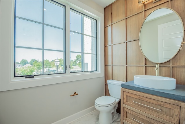 bathroom featuring oversized vanity, tile flooring, toilet, and a wealth of natural light