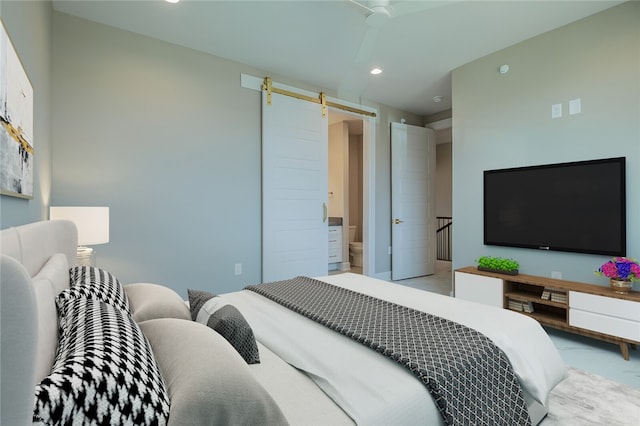 bedroom with a barn door, ceiling fan, and connected bathroom