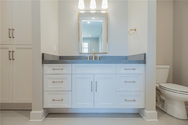 bathroom featuring toilet, tile flooring, and vanity