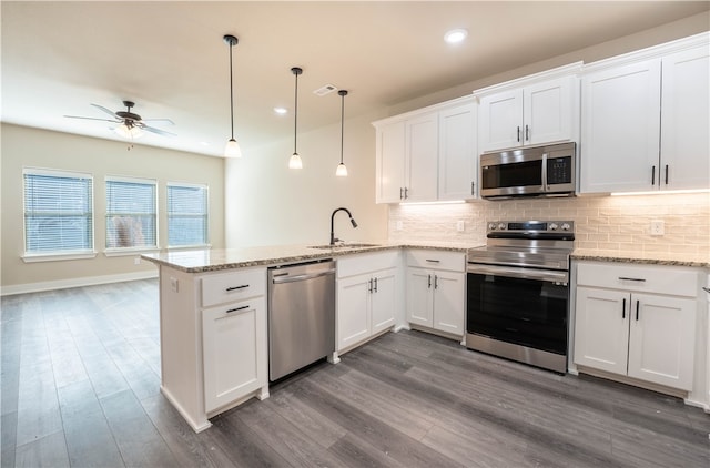 kitchen featuring kitchen peninsula, white cabinetry, stainless steel appliances, and pendant lighting