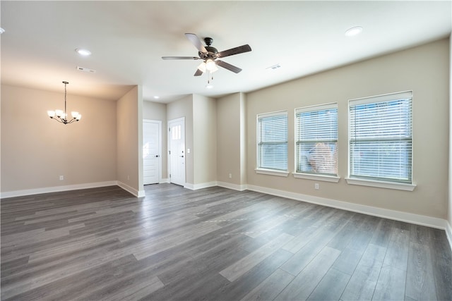 spare room with dark hardwood / wood-style floors and ceiling fan with notable chandelier