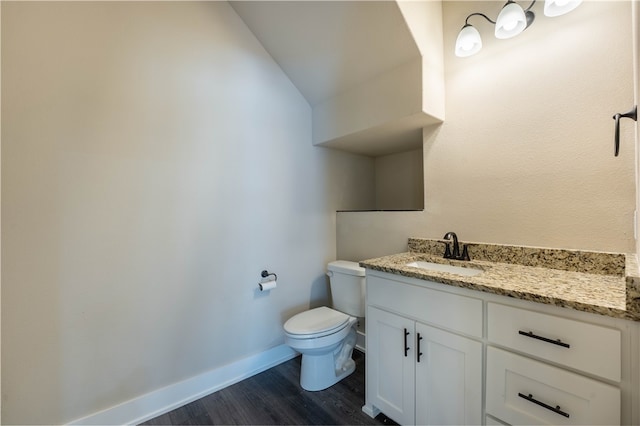 bathroom with vanity, vaulted ceiling, hardwood / wood-style flooring, and toilet